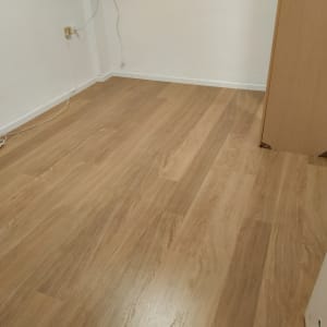 רצפת פרקט עץ בחדר ריק עם קיר לבן