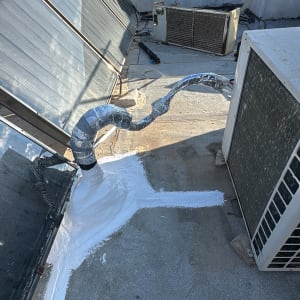 איטום גג עם חומר לבן ליד צינור ומזגן