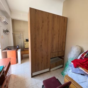 חדר עם ארון בגדים, כיסא ומיטה עם מצעים