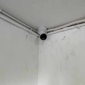 מצלמת אבטחה מותקנת בפינת תקרה עם חיווט גלוי