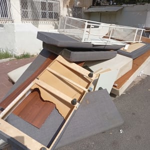 רהיטים ישנים ופסולת ברחוב ליד בניין מגורים