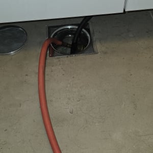 צינור אדום ושחור מחוברים לניקוז ברצפה