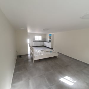 חדר עם רצפת אריחים, מיטה מכוסה בניילון