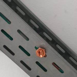 מסילת מתכת עם ברגים וחוטי חשמל