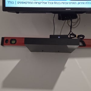 מדף עם טלוויזיה ומפלס על קיר לבן