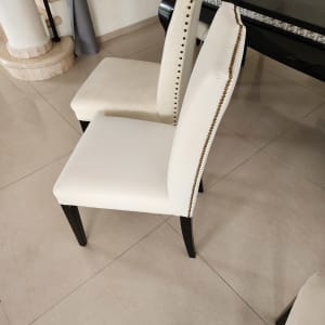 כיסאות מרופדים בלבן עם מסמרי קישוט זהובים