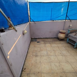 מרפסת עם רצפה מרוצפת וקירות עם כיסוי בד כחול