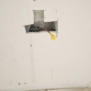 קיר עם חור ותשתית חשמל חשופה