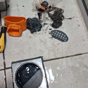 כלי עבודה לניקוי סתימה בביוב על רצפה רטובה