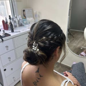 אישה עם תסרוקת קלועה וסיכה עם פנינים