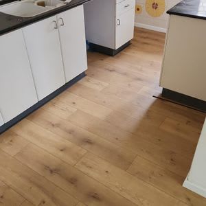 רצפת פרקט עץ במטבח עם ארונות לבנים