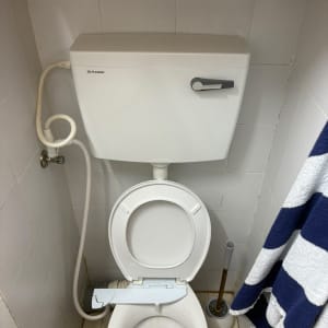 אסלה עם מיכל הדחה ומברשת ניקוי בחדר אמבטיה