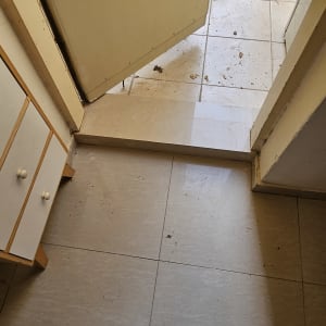 נעליים מלוכלכות על רצפה ליד דלת פתוחה