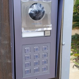 פאנל אינטרקום עם מצלמה ומקשים על עמוד עץ