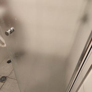 דלת מקלחת מזכוכית עם ידית מתכת