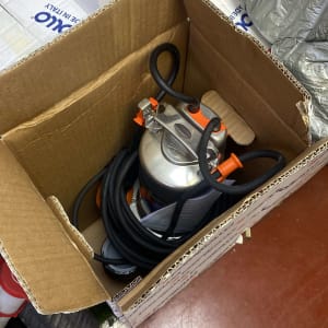 משאבה מתכתית עם צינור שחור בתוך קופסה