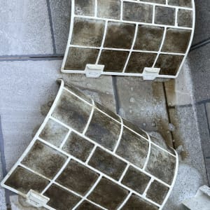 מסננים מלוכלכים של מזגן בתהליך ניקוי