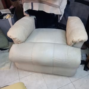 כורסה מרופדת בלבן עם כריות ידיים