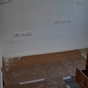 קיר צבוע עם סימני צבע, רצפה מכוסה בנייר