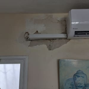 קיר עם מזגן ונזק לקיר לידו