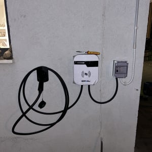 מטען לרכב חשמלי מותקן על קיר עם כבל טעינה