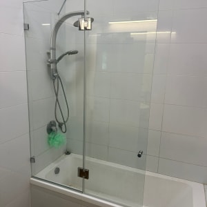מקלחון זכוכית בחדר אמבטיה עם אריחים לבנים