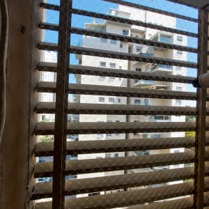 רשת מתכת על חלון למניעת כניסת יונים