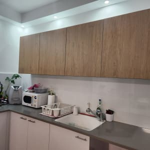 מטבח עם ארונות עץ, כיור וכלי מטבח שונים