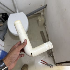 תמונה של שירותים עם צינור פגום וכלי עבודה