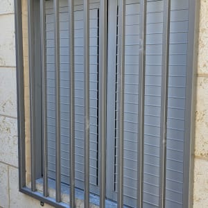 סורגי מתכת על חלון קיר אבן
