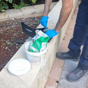 אדם עם כפפות כחולות משתמש במלכודת מזיקים