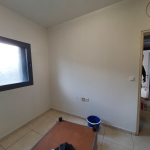 דלי כחול וחומרי צביעה בחדר