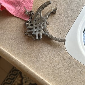 מסננת מתכת ישנה על משטח ליד כיור