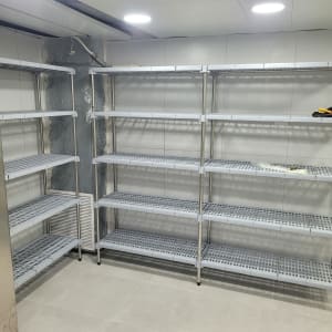 מדפים מתכתיים מותקנים בחדר עם כלי עבודה