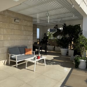 פרגולה מאלומיניום עם ריהוט גן וצמחים