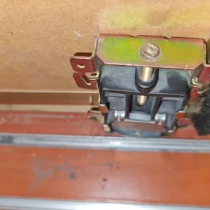 גלגל מתכת מחובר לדלת עץ עם מסילה