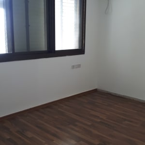 חדר עם קירות צבועים בלבן ורצפת עץ