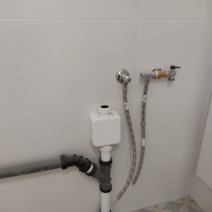 צינורות מים וברזים מחוברים לקיר בחדר אמבטיה