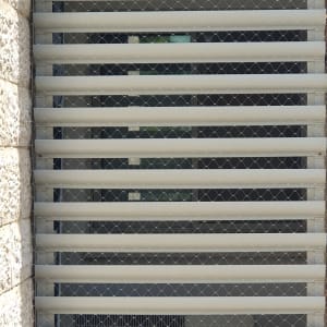 רשת מתכת על חלון למניעת כניסת יונים