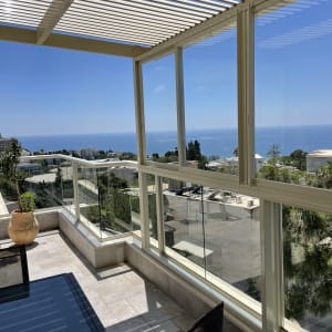 מרפסת עם חלונות זכוכית נקיים ושולחן זכוכית