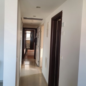 מסדרון עם קירות צבועים בלבן ודלתות חומות