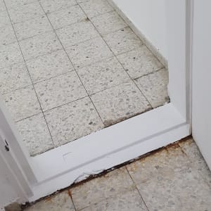 רצפה מלוכלכת עם כתמי חלודה ולכלוך בפינות