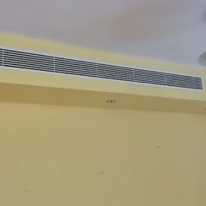 פתח אוורור של מזגן על קיר צהוב