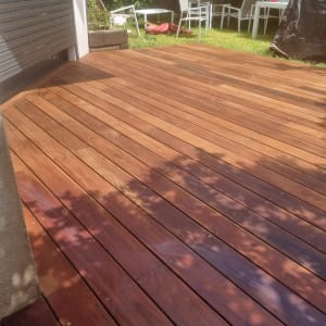 דק עץ בגינה עם צללים של עלים