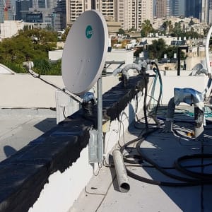 איטום גג עם חומר שחור ליד צלחת לוויין