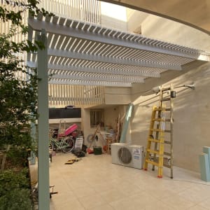 פרגולה מעץ עם סולם צהוב בחצר