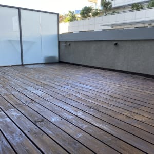 רצפת עץ חיצונית עם מחיצה זכוכית אטומה