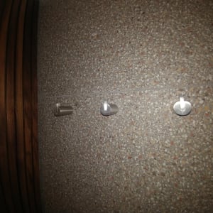 שלושה ווים מתכתיים על קיר אבן