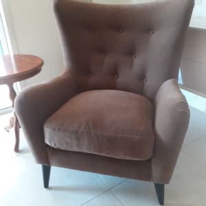 כורסה חומה מרופדת עם רגליים שחורות