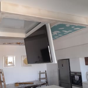 תקרת גבס עם טלוויזיה תלויה בתהליך התקנה